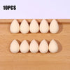 Ten white makeup sponge puffs arranged in two rows on a wooden surface.
