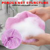 A hand holds a pink porous net structure bath sponge creating luxurious lather.