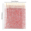 A clear plastic kit containing numerous crystal lip brushes and lash spoolies with red accents.