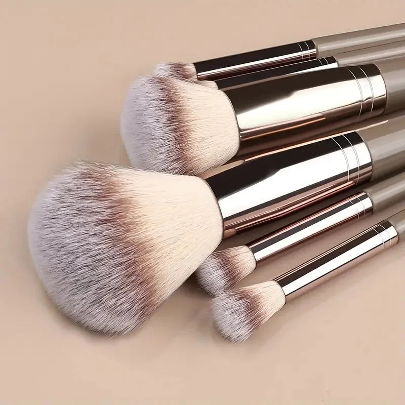 A set of makeup brushes with silver handles and fluffy, light beige bristles.
