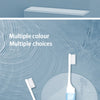 Un set de mini-brosses à dents pliables de différentes couleurs sur un fond bleu clair.