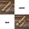 A pair of bamboo toothbrushes, one colorful and one black, are shown on a wooden surface.