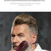 A man is holding a dark wooden boar bristle hair and beard brush near his face.