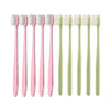 A row of pink and light green ultra-soft microbristle toothbrushes.