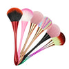 A set of rose gold dusting and makeup removal brushes with various pink, red, and green bristles.