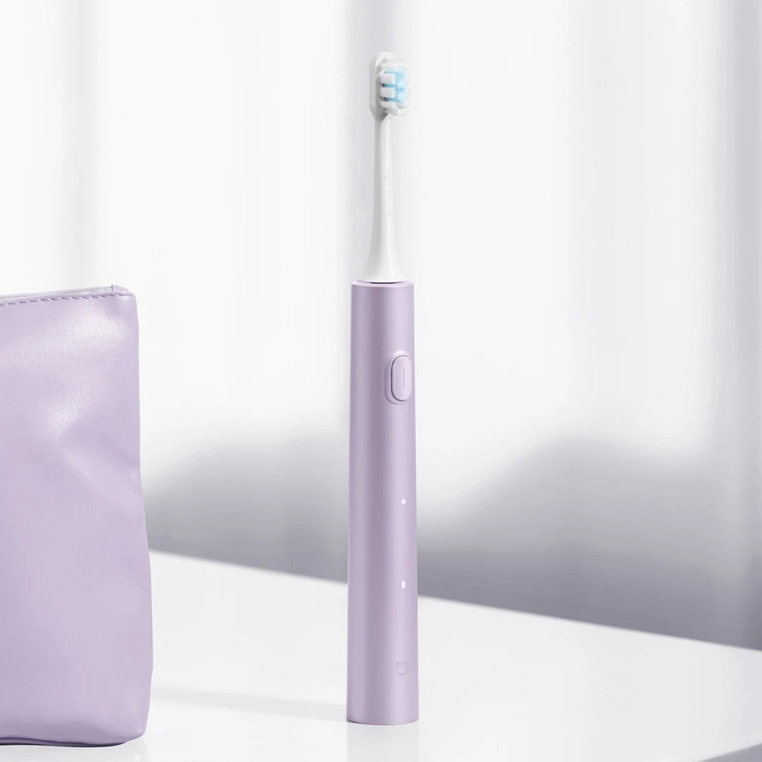 A purple sonic electric toothbrush standing upright next to a purple case.