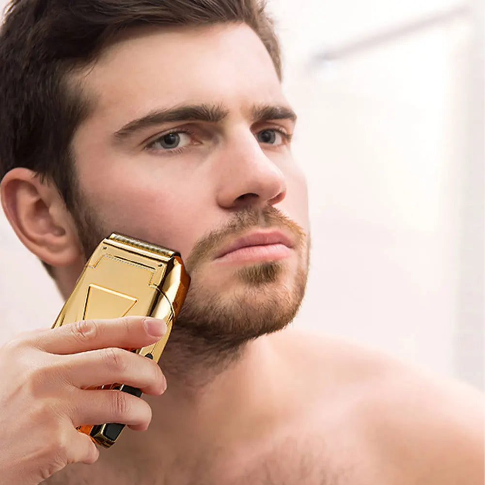 A man is holding a gold-colored electric shaver kit near his face.