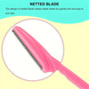 A close-up view of a pink netted blade razor, showing the serrated edge and handle.