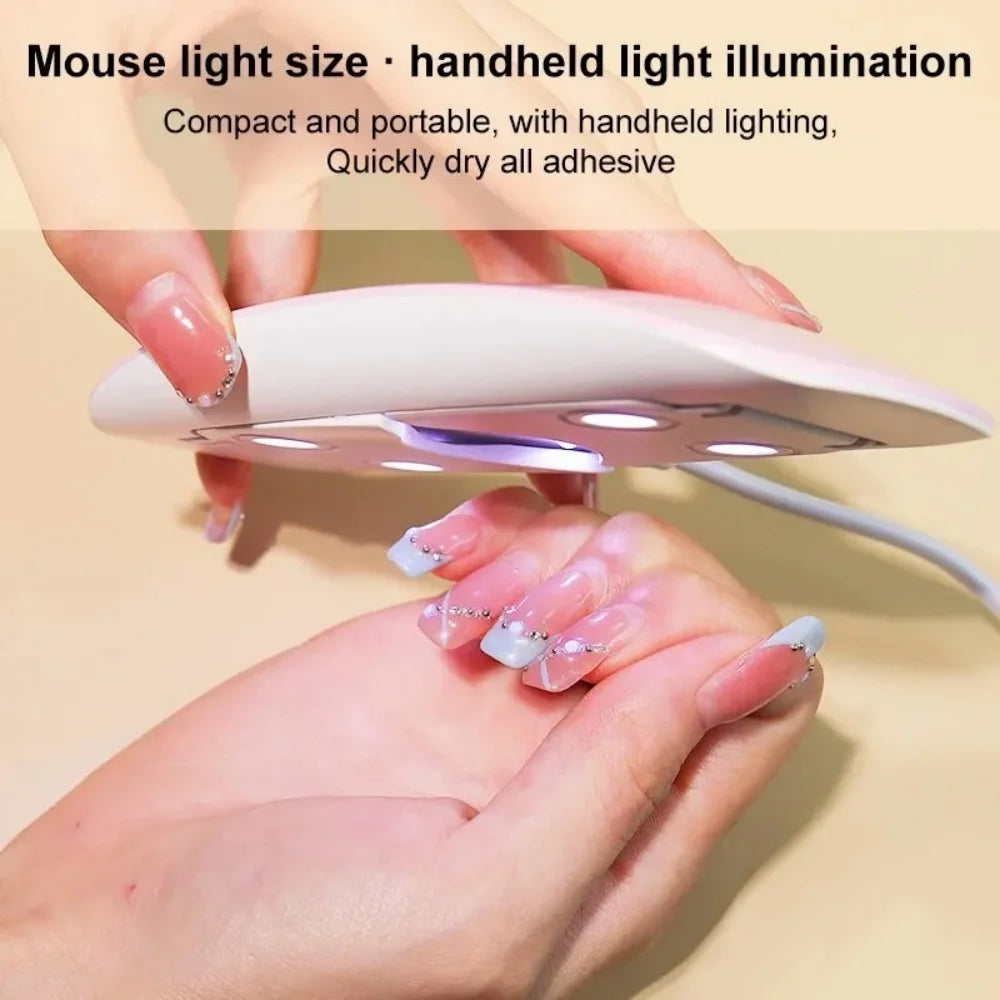 Hands hold a white handheld light illuminating a nail, demonstrating portable UV LED nail dryer lamp usage.