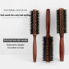 A set of wooden roll combs for curly hair styling, showing the comb and its notched non-slip handle.