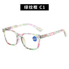 Pair of green and pink patterned reading glasses with clear frames.