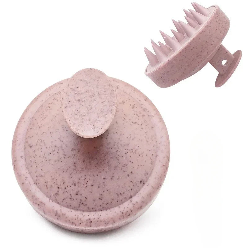 A pink silicone scalp massage and body brush with a textured head and a flat base.
