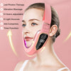 A woman is using a pink facial lifting massager with LED photon therapy on her face.