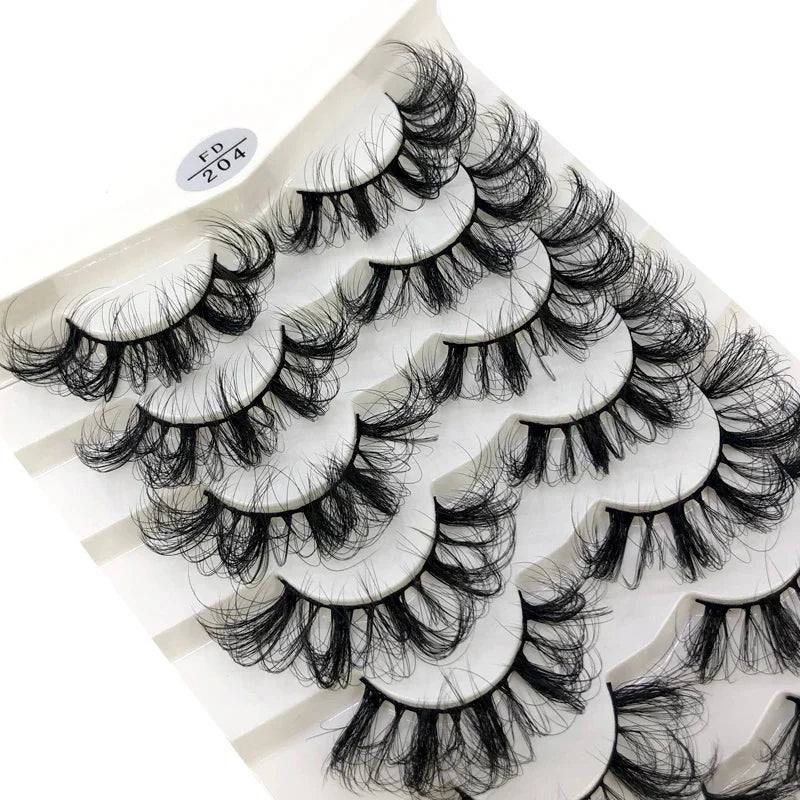 Gros plan d'un pack de 8 faux cils en mink de qualité sur une surface blanche.