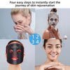 A woman applying a multi-wavelength LED face therapy mask to her face for skin rejuvenation.