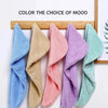 A collection of colorful microfiber hair towels wrapped and displayed on a wooden rack.