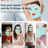 A woman is applying a light therapy face mask to her face, demonstrating its use for skin rejuvenation.