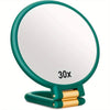 A green magnifying mirror with a gold-colored folding handle.