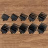 A set of black replacement clipper guards numbered 1 through 8 laid out on a wooden surface.