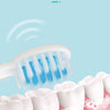 A white electric toothbrush with blue bristles is shown cleaning teeth on pink gums.