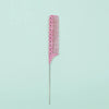 A pink anti-static rat tail comb with fine teeth shown against a light mint green background.