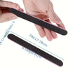 A hand holds a black dual-grit nail file, showing its dimensions and shape.