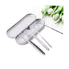 Stainless steel tongue scrapers set with a clear storage case and a sprig of white leaves