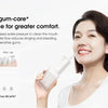 A woman smiles while using an electric oral irrigator for a cleaner, gum-care experience.