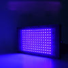 A rectangular UV curing lamp emitting bright purple light, illuminating a surface.