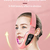 A woman is using a pink facial lifting massager with LED therapy on her face.
