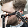 A man is using a black rechargeable hair clipper to engrave patterns onto his beard.