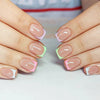 Gros plan sur des mains montrant des ongles press-on acryliques colorés avec des accents rose et vert lime