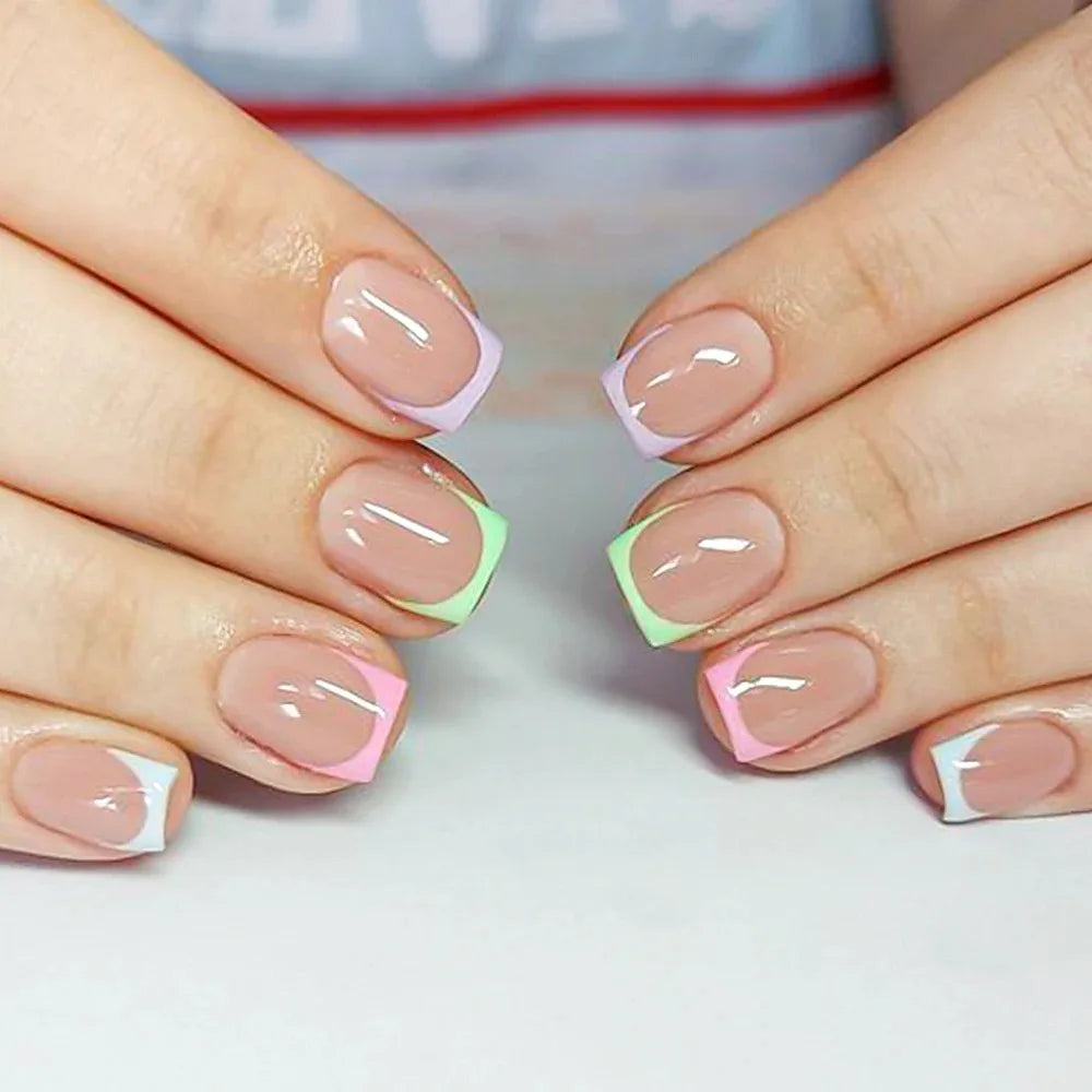Gros plan sur des mains montrant des ongles press-on acryliques colorés avec des accents rose et vert lime