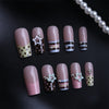 Press-on nails featuring a pink and brown French wave design with star accents on a black background.