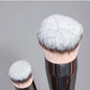 Primer plano de un set de brochas de maquillaje profesional con cerdas sintéticas blancas suaves y mango metálico.