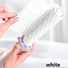 A hand is holding a white silicone heat resistant mat for hair styling tools, showing its textured surface.