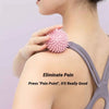 A hand is pressing a pink textured massage ball onto the shoulder of a person to alleviate pain.