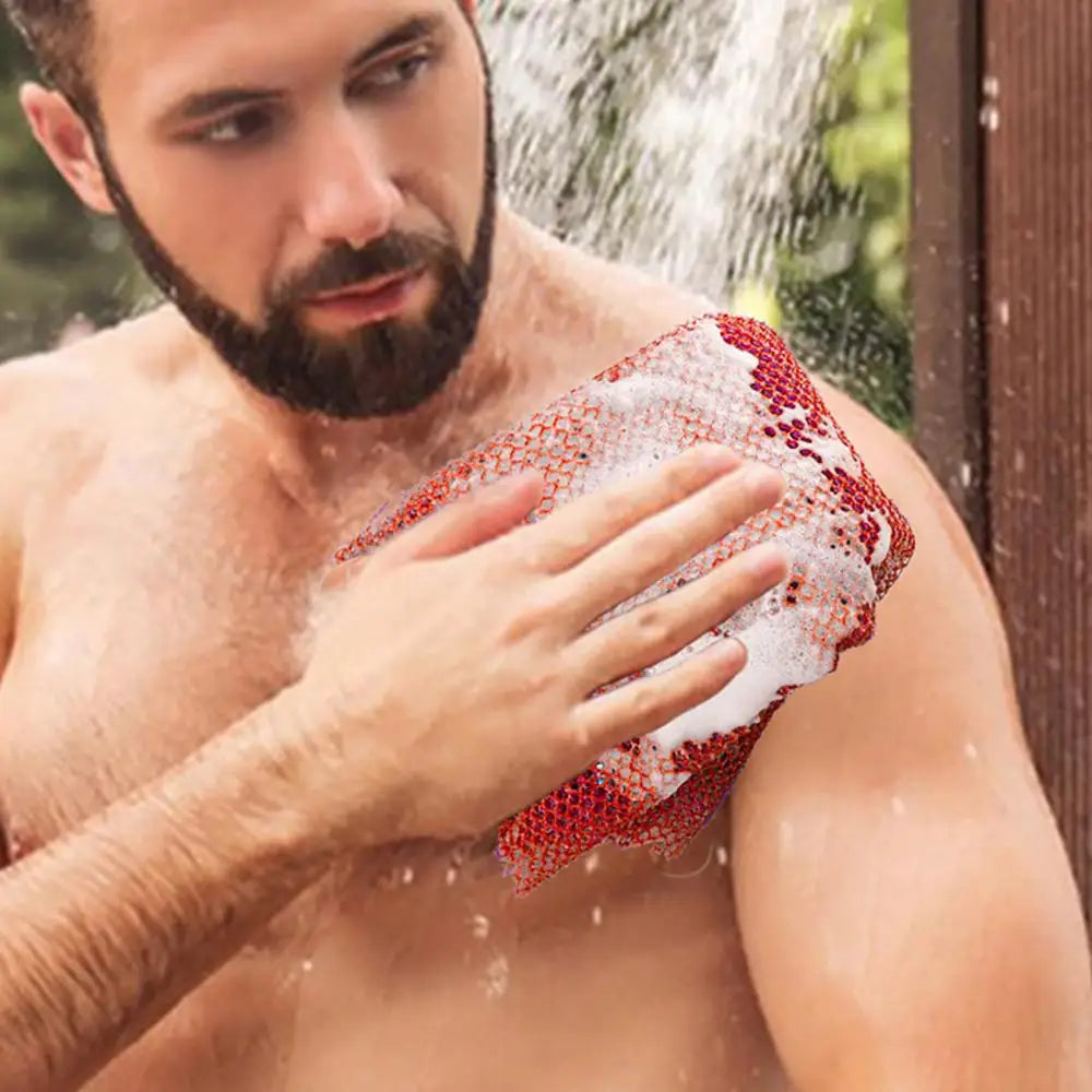 Un homme utilise une éponge exfoliante colorée et réutilisable pour le corps sur sa peau avec de l'eau.