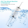 A white portable USB rechargeable water flosser is shown spraying water into a glass of water.
