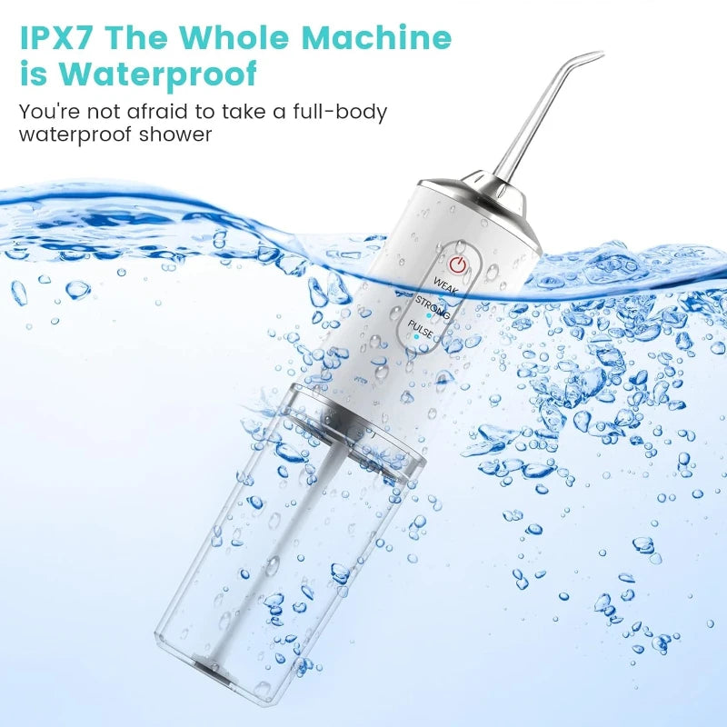 A white portable USB rechargeable water flosser is shown spraying water into a glass of water.