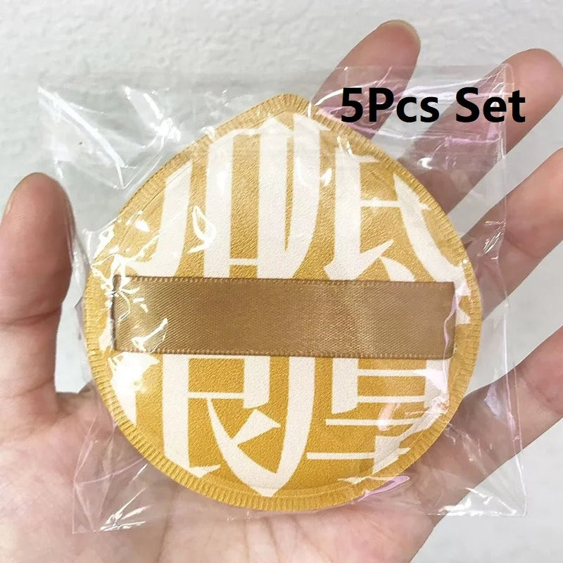A set of five beige makeup puffs packaged in a clear plastic bag with a storage box.