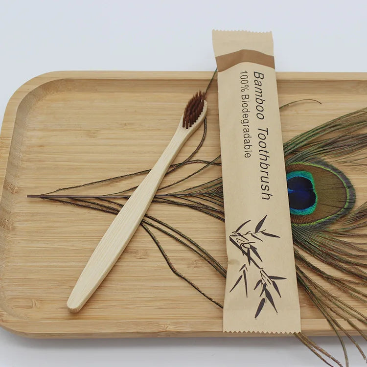A bamboo toothbrush packaged in natural paper on a wooden cutting board.