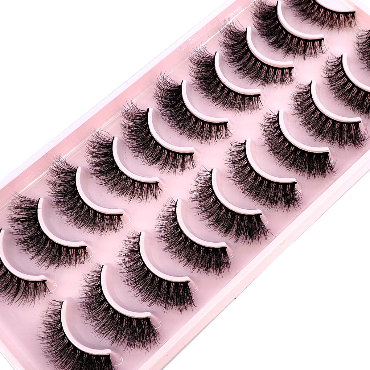 A tray of ten pairs of natural look false mink eyelashes displayed on a pink background.