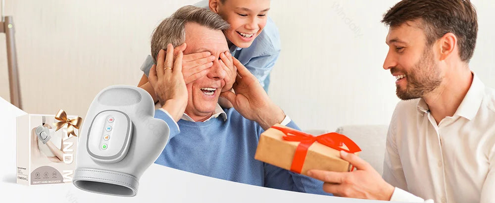 A man is using an electric hand massager on an elderly man while a younger boy watches, with a man holding a gift box.