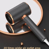 A sleek, black hair dryer with a gold accent is shown against a dark background.