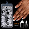 Une main tient un contenant en plastique transparent rempli de pointes de ongles en acrylique pour fausses ongles.