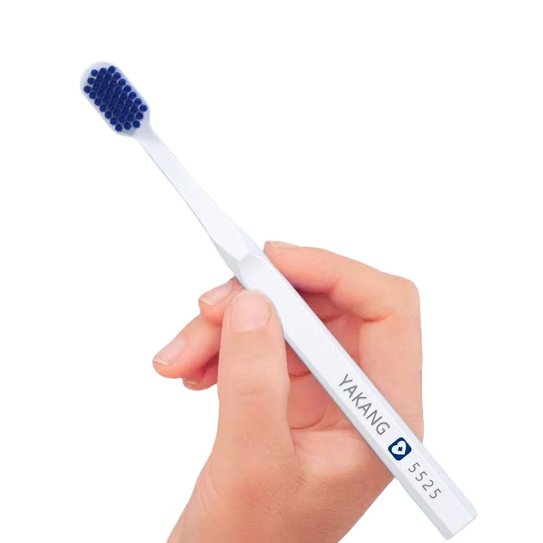 A hand holds a white toothbrush with blue bristles, demonstrating the extra large brush for deep gum cleaning.