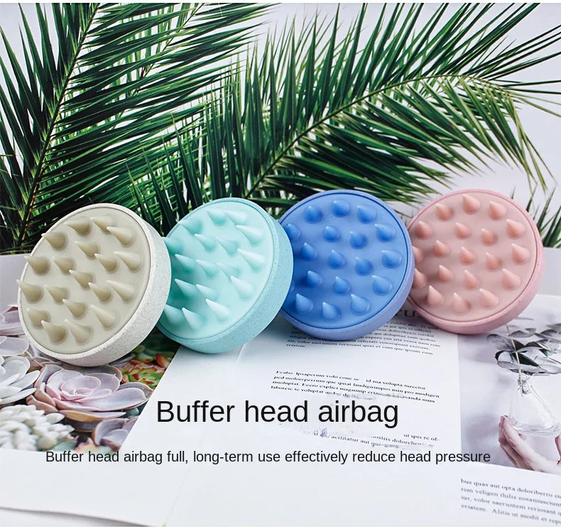 A set of pink, blue, and white rubber buffer head airbags for scalp massage shown against a green palm leaf background.