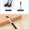 A black makeup brush with a fine tip used for contouring and nose shadow application.