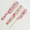 A set of two pink and green floral dual hair combs displayed on a white background.